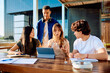 © we.bond.creations - Young diverse students collaborating on a university project, discussing ideas and sharing information using a modern tablet outdoors