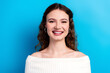 © deagreez - Young smiling woman portrait with off-shoulder white top against bright blue background conveying confidence and natural beauty