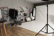 © Pixel-Shot - Interior of photo studio with professional equipment, clothes rack and pin board