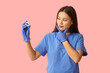 © Pixel-Shot - Thoughtful female dentist with dental floss on pink background