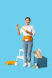 © Pixel-Shot - Female Asian decorator with tape measure on blue background