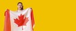 © Pixel-Shot - Young Asian woman holding flag of Canada on yellow background with space for text