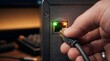 © Adobe - A hand holding an ethernet cable and plugging it into a lan port on a computer or router with glowing green and orange lights