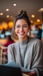© NovaVision - Young woman with glasses and a messy bun smiling brightly in a cozy cafe setting