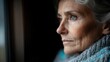 © Larisa AI - An elderly woman with gray hair gazes thoughtfully out of a window, reflecting a deep sense of wisdom, emotion, and the beauty of solitude in a quiet moment.