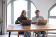© luciano - Couple Working Together on Laptops at Home Office Table Collaborating Remotely