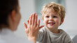 © KotBaton - Happy child giving high five to parent, positive parenting, bonding, encouragement and emotional development in bright home interior.