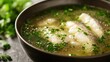 © Adi - Close Up of Gourmet Catfish Soup with Herbs in a Bowl