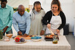 © Sabrina - Happy african family cooking together healthy vegetarian dinner during summer time at house terrace - Food, weekend and lifestyle concept