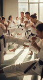 Martial arts students practicing kicks and punches in a sunlit dojo, fostering discipline and teamwork. Ideal for fitness and self-defense.