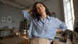 © AZ Studio - Young Middle Eastern woman enjoying music with wireless earbuds in a bright home office