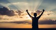 © Nur - Silhouette of a Successful Man Raising Arms in Victory Against a Beautiful Sunset with Radiant Sun Rays