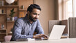 © insta_photos - Smiling indian business man working on laptop at home office. Young indian student or remote teacher using computer remote studying, virtual training, watching online education webinar at home office.