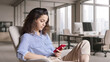 © insta_photos - Hispanic young woman holding smartphone using phone in modern creative office. Latin girl student looking at cell studying, browsing, checking apps on mobile technology gadget in university campus.