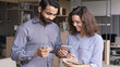 © insta_photos - Indian and hispanic happy colleagues talk use digital tablet in office. Male mentor, manager having friendly discussion with female latin coworker collaborate in teamwork work on project together.