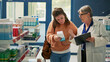 © DC Studio - Female customer dealing with stomachache asking specialist about pills or painkillers, food poisoning. Client with abdominal cramps or gastritis in pharmacy shop, looking for medicaments.
