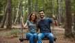 © Ant - A happy young couple enjoys swinging together in a peaceful forest setting, surrounded by trees and natural greenery.