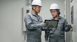 © 望見 柿元 - DX化を導入した日本人の電気工事士がタブレットを手に配電盤を点検する、女性進出と若手育成に注力する製造現場の様子、コピースペースのある構図