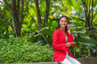 © StockPhotoRepublic - Young Asian Woman talking on a smartphone while holding a credit card in a garden