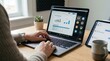 © Thea - Remote worker attending online video conference meeting on laptop with project charts and team members visible on screen at home desk.