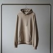 © Flaster - Beige hoodie on metal clothing rack.