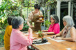 © Ekkasit A Siam - Young cafe server brings iced drink and dessert to senior Asian women meeting again after long separation, starting heartfelt lunch conversation about life change, friendship support, comfort, warmth.