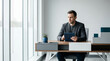 © Arties - Businessman using tablet while sitting at desk in modern office