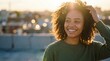 © Bright Stock - Portrait of a smiling curly-haired woman in warm sunset light with city bokeh background, natural lifestyle and positive mood