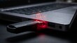© musgraphy - A close-up view of a USB drive plugged into a laptop with warning signs indicating a potential security threat