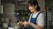 © GANBA - 明るいキッチンで手料理を作る幸せそうな女性