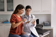 © fizkes - Doctor showing medical information to woman patient on digital tablet, providing lab test results, explaining diagnosis, X-ray imaging, MRI scans, giving medical consultation about treatment options