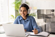 © fizkes - Smiling businesswoman in headphones working or studying at laptop in office, engaged in online meeting or virtual training session, gains new skills, e-learns at workplace. Professional development