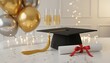 © antuanetto - Color image of cheerful graduation party with mortarboard and diploma for academic success concept at a formal graduation ball celebration with champagne and gold balloons