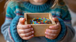 © Nataliya - Close-up of child hands holding a handmade beaded bracelet in a small open jewelry box, handcrafted gift for mom, creative holiday concept, with copy space