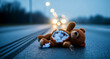 © MARGARYAN GOR - Torn teddy bear lying on a wet road with approaching car headlights. Discarded toy on dark asphalt during rainy night. Child safety and accident awareness concept for social campaigns.