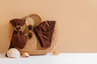 © Pixel-Shot - Wicker bag with brown swimsuit, sunglasses and seashells on color background