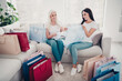 © deagreez - Mother and daughter trying on clothes together at home surrounded by colorful shopping bags and smiling after a successful shopping day