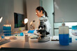 © Parichat - Scientist conducting research experiment visualizing cells using microscope