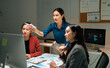 © Parichat - Businesswomen collaborating on financial data in a dark office
