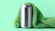 © backup_studio - Aluminum soda can draped with a soft green textured towel. Minimalist product display for beverage marketing. Creative advertising concept for refreshing drink refreshment cold liquid.
