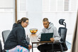 © Jordi Mora - Personal trainer showing workout plan to client on laptop in office