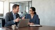 © Eve - Professional male manager explaining task to young brunette businesswoman with glasses. Business meeting, mentorship, and corporate consulting concept in modern office.