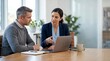 © Eve - Professional businesswoman showing project to male colleague on laptop. Business team discussing strategy and analysis during meeting in modern light office workspace.