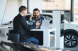 © Serhii - Car salesman discussing financing with customer at dealership