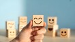© Intellectual - world mental health day concept or feedback rating and positive customer review, Businessman hand holding smile face, wood cube with happiness face icon on blue background