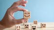 © Intellectual - world mental health day concept or feedback rating and positive customer review, Businessman hand holding smile face, wood cube with happiness face icon on blue background