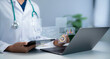 © Toowongsa - Doctor using tablet and laptop analyzing patient data with virtual dashboard showing risk monitoring healthcare analytics medical technology clinical decision support improving care