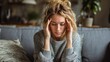 © Dao - Woman, sofa and stress with headache, migraine or anxiety with massaging temple in living room. Tension, mental health and wellness discomfort, crisis and worried female person frustrated in home