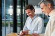 © Westend61 - Two men in an office having a business meeting with a tablet