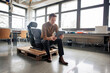 © Westend61 - Engineer using tablet PC sitting on chair over pallet at workshop